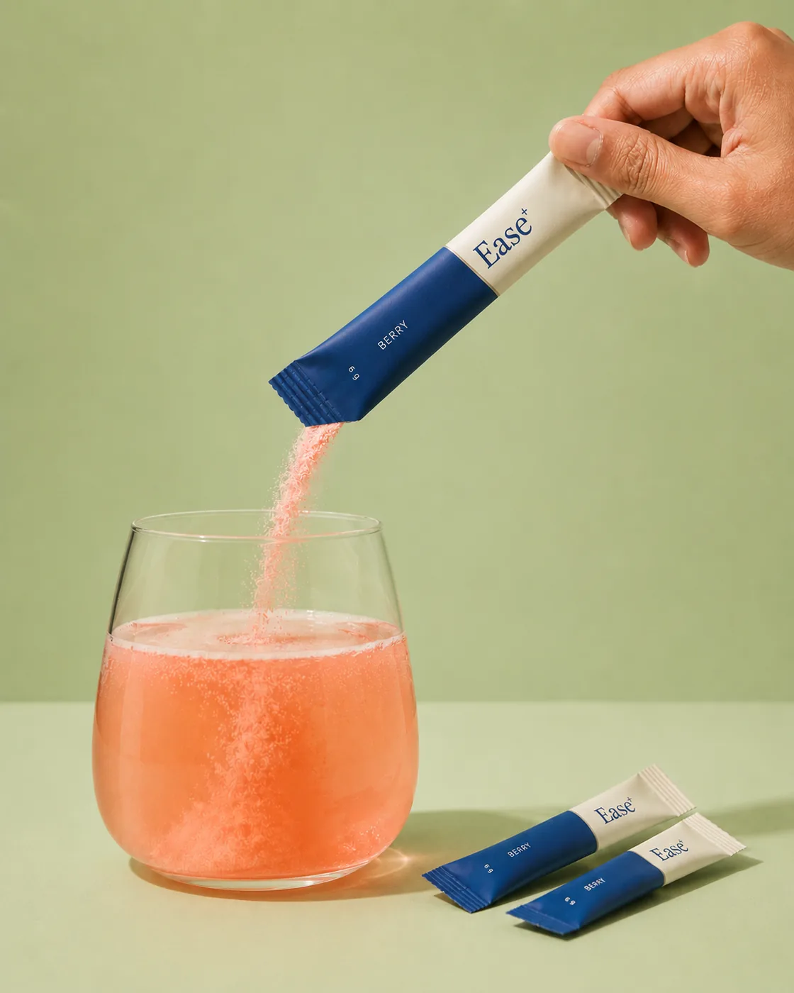 Pouring a berry Ease sachet into a glass of water