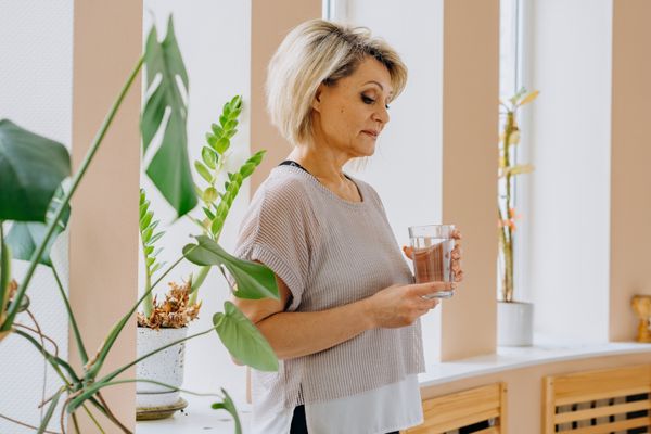 A woman holding a glass of water
