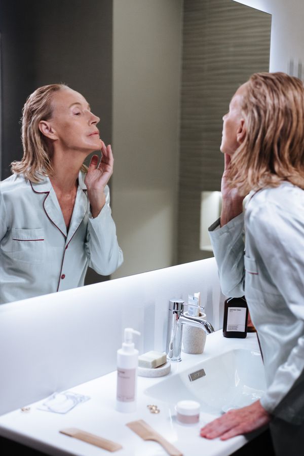 A woman checking her skin in the mirror