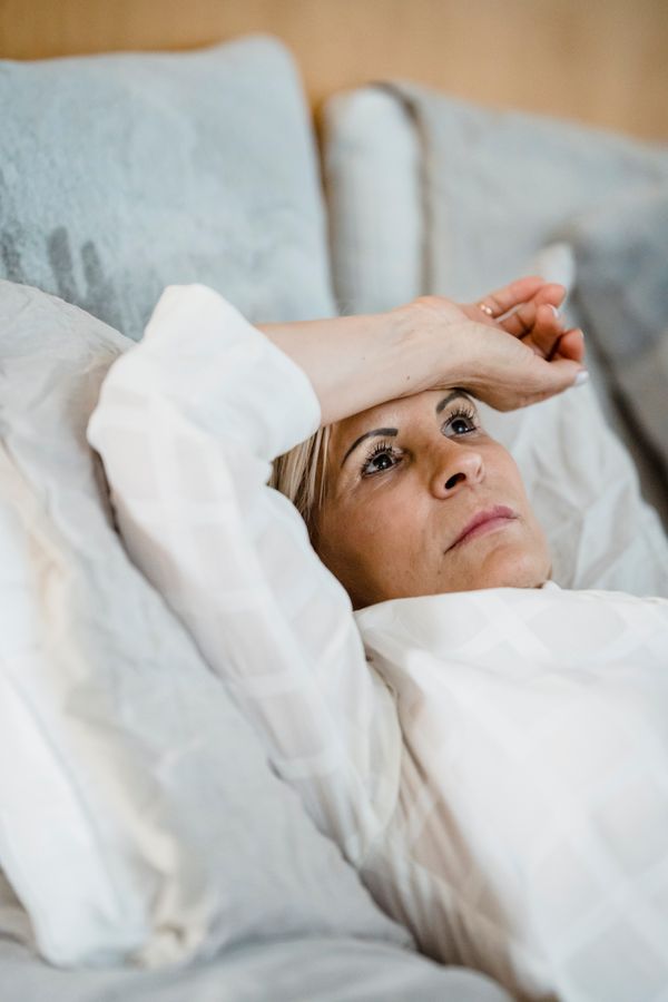 A woman lying in bed feeling hot